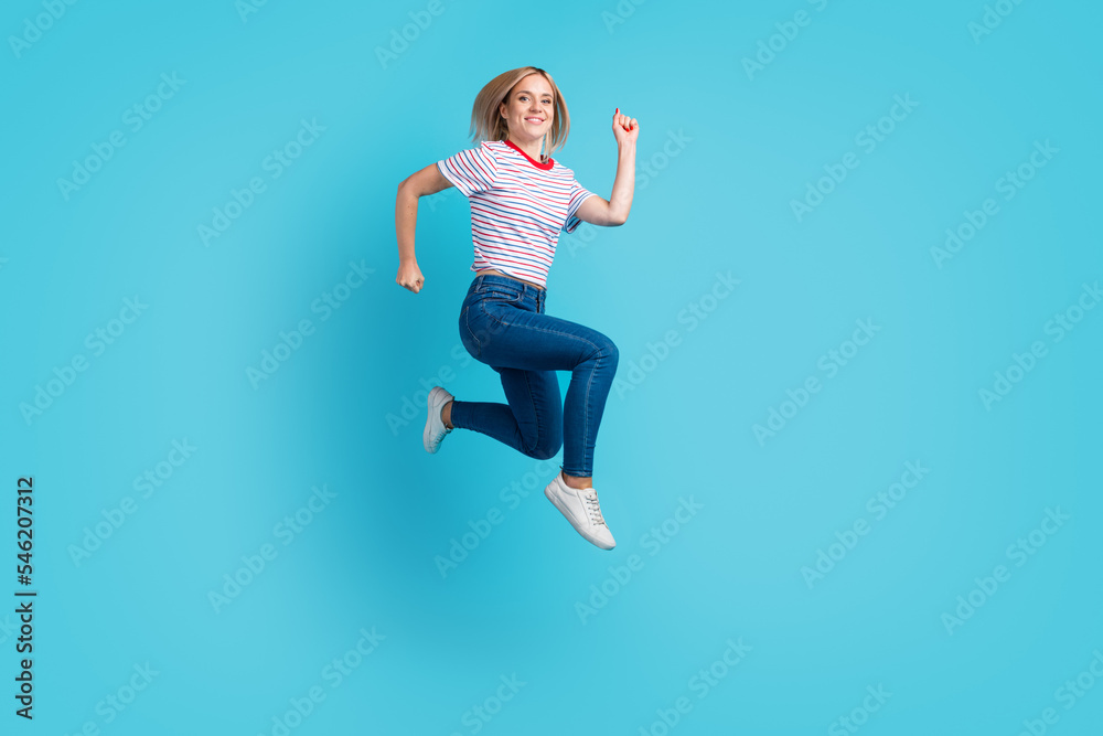 Full length body photo of pretty girl jumping up smiling overjoyed isolated on blue color background