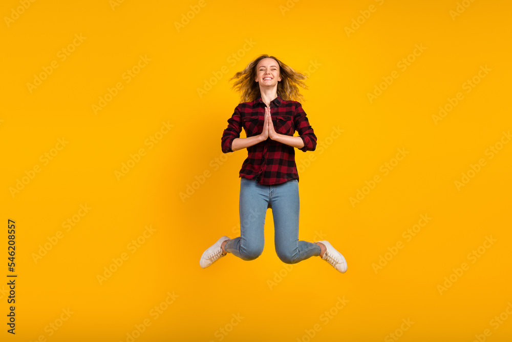 Full body view of lovely cheerful wavy-haired girl jumping hands plead isolated on bright vivid shine vibrant background
