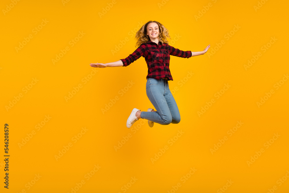 Full size view of lovely glad wavy-haired girl jumping having fun rising hands isolated on vivid shine vibrant background Full size view of lovely glad wavy-haired girl jumping having fun rising hands isolated on vivid shine vibrant background