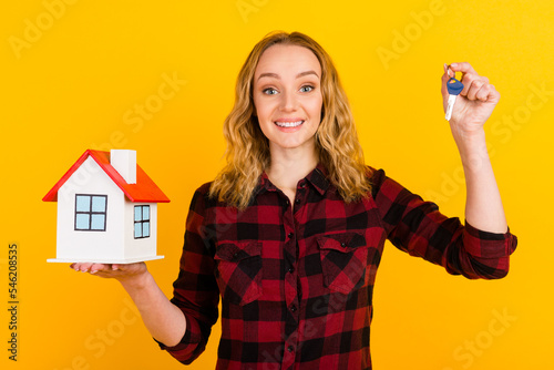 Smiling young woman girl posing isolated on bright wall background portrait. People hold hands house bunch of keys