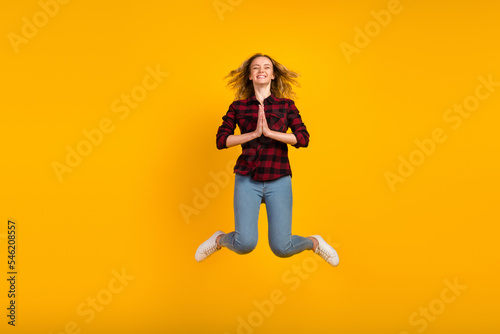Fototapeta Naklejka Na Ścianę i Meble -  Full body view of lovely cheerful wavy-haired girl jumping hands plead isolated on bright vivid shine vibrant background