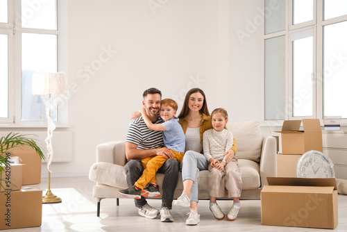 Happy family sitting on couch in new apartment. Moving day