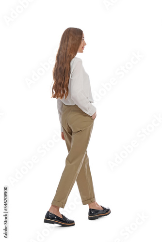 Young woman in casual outfit walking on white background