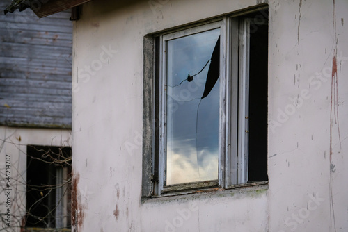 Abandoned, vandalized residential building. Broken glass, slum, desolation. Defocused.