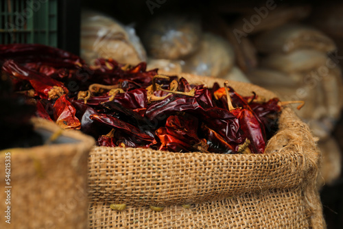 Pile of dried guajillo peppers in burlap, closeup photo