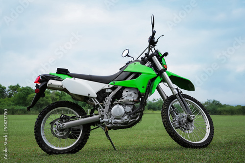 Stylish cross motorcycle on green grass outdoors © New Africa
