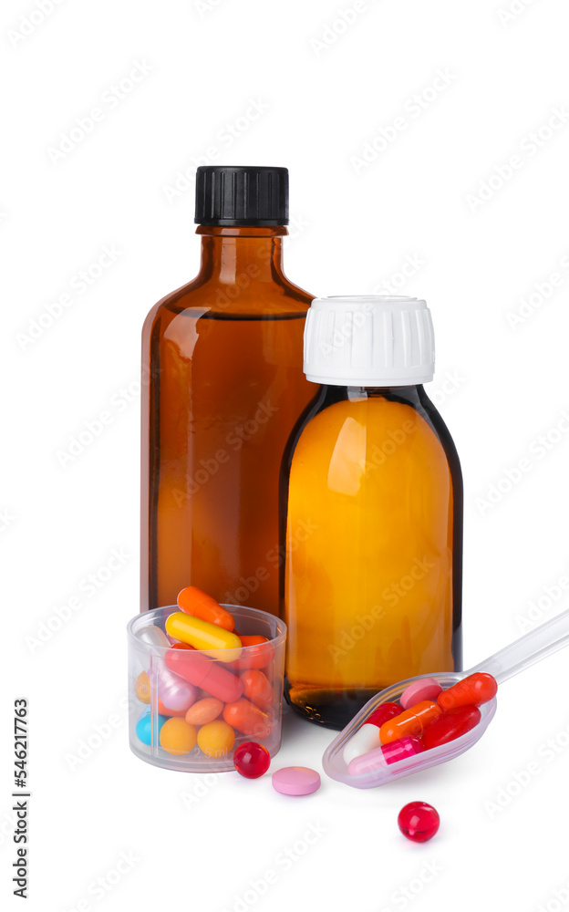 Bottles of syrups, measuring cup, plastic spoon with pills on white background. Cough and cold medicine Bottles of syrups, measuring cup, plastic spoon with pills on white background. Cough and cold medicine