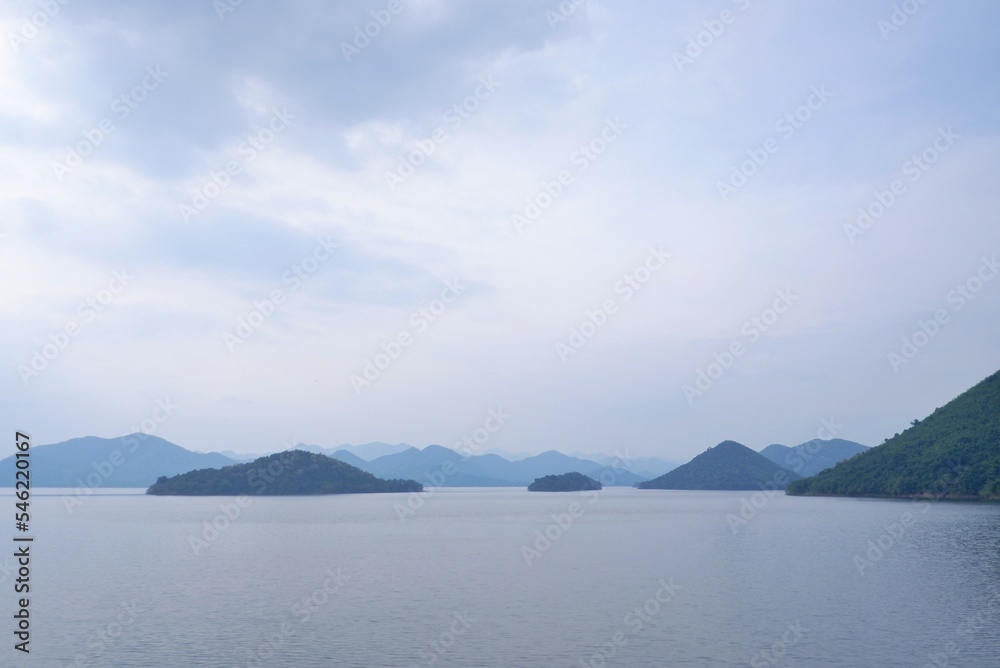 In selective focus a beautiful Kaeng Krachan dam with lake view and many hill along river side,blue sky background 