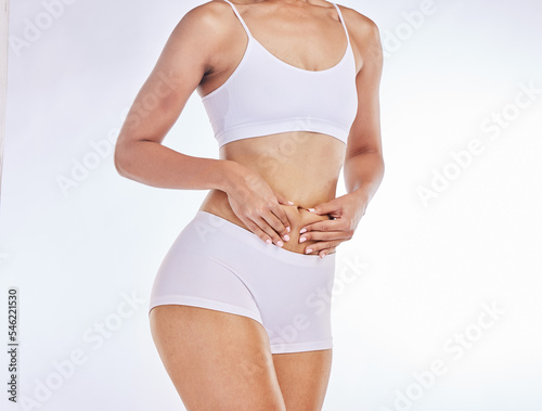Body, diet and underwear woman in studio with hands on stomach for fitness goals, cardio wellness or gut health on mockup marketing space. Fashion, lingerie and model with tummy tuck or abdomen care