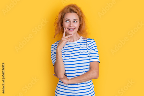 pondering redhead woman portrait isolated on yellow background. portrait of young redhead woman