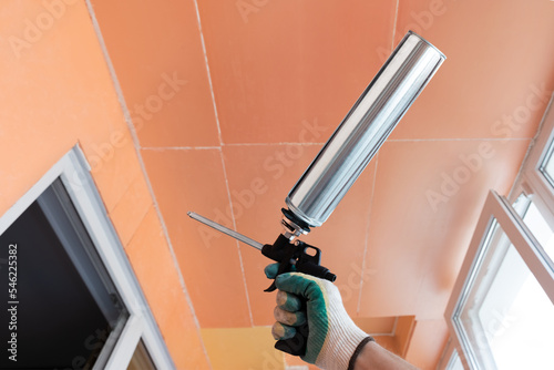 Wallpaper Mural Construction gun with polyurethane foam in a male hand. Warming of rooms and sealing of seams between expanded polystyrene. The concept of pasting with extruded polystyrene foam. Torontodigital.ca