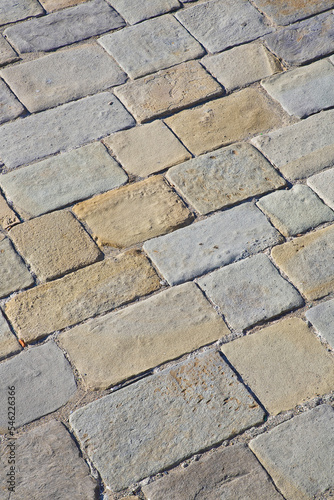 Old and damaged italian paving made with chiseled grey sandstone