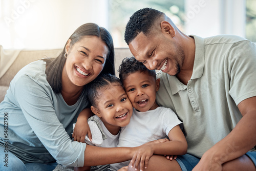 Happy, love and family portrait with kids, parents and relax on a sofa with a smile in the living room. Happiness, care and mom with dad sitting and holding children with joy on a couch in home. © David L/peopleimages.com