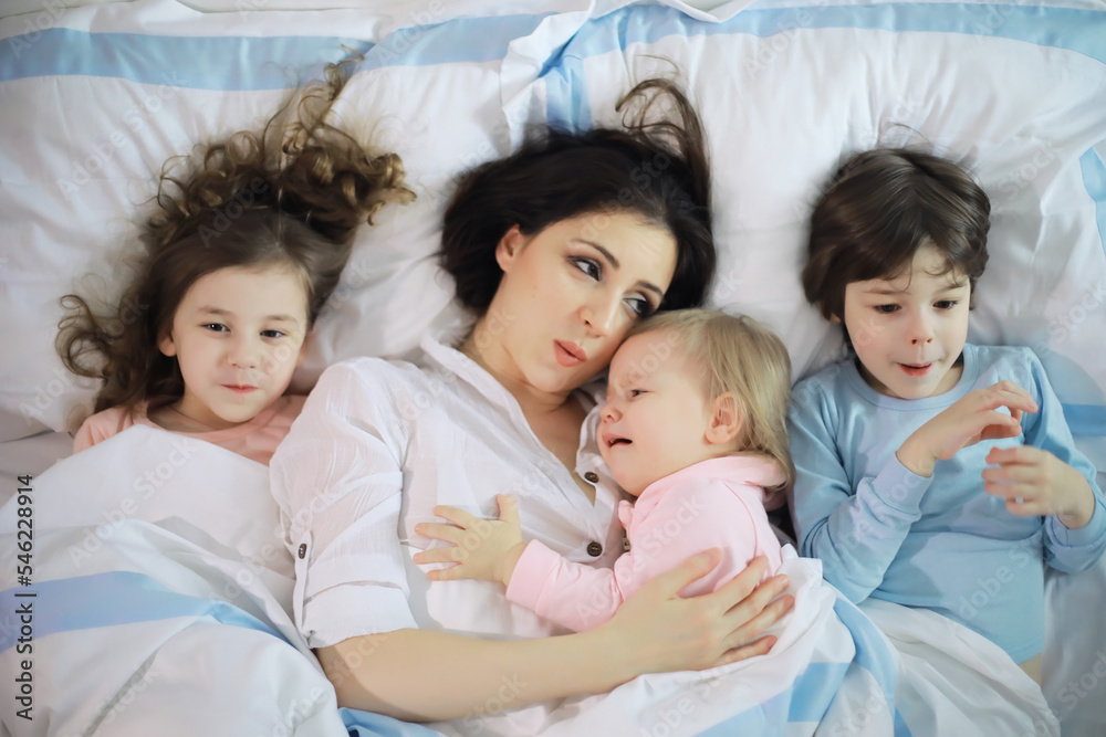 A family with children having fun on the bed under the covers during the Christmas holidays. A family with children having fun on the bed under the covers during the Christmas holidays.
