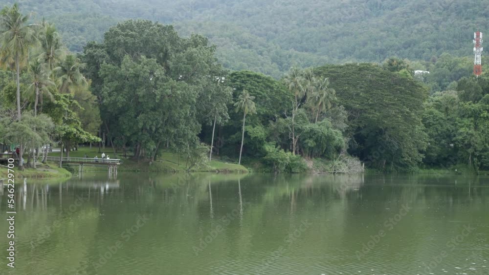 natural green view of reservoir lake with green mountain range with some cloud mist fog in background, natural rainy season landscape view in Chiang Mai natural green view of reservoir lake with green mountain range with some cloud mist fog in background, natural rainy season landscape view in Chiang Mai