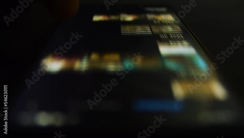 Man look in mobile phone and browse through gallery. Close up. Relaxed adult male browsing app cell phone