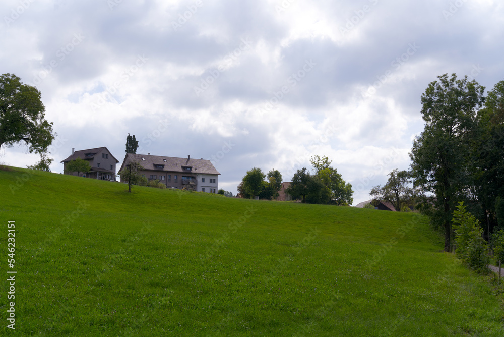 Scenic view of rural Ettenhausen hamlet with old farm houses on a cloudy late summer day. Photo taken September 1st, 2022, Ettenhausen, Switzerland. Scenic view of rural Ettenhausen hamlet with old farm houses on a cloudy late summer day. Photo taken September 1st, 2022, Ettenhausen, Switzerland.