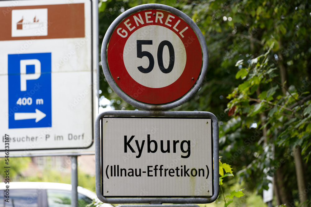 Speed limit sign 50 kilometers per hour and road sign of Kyburg, Canton Zürich, on a cloudy late summer day. Photo taken September 1st, 2022, Kyburg, Switzerland.
