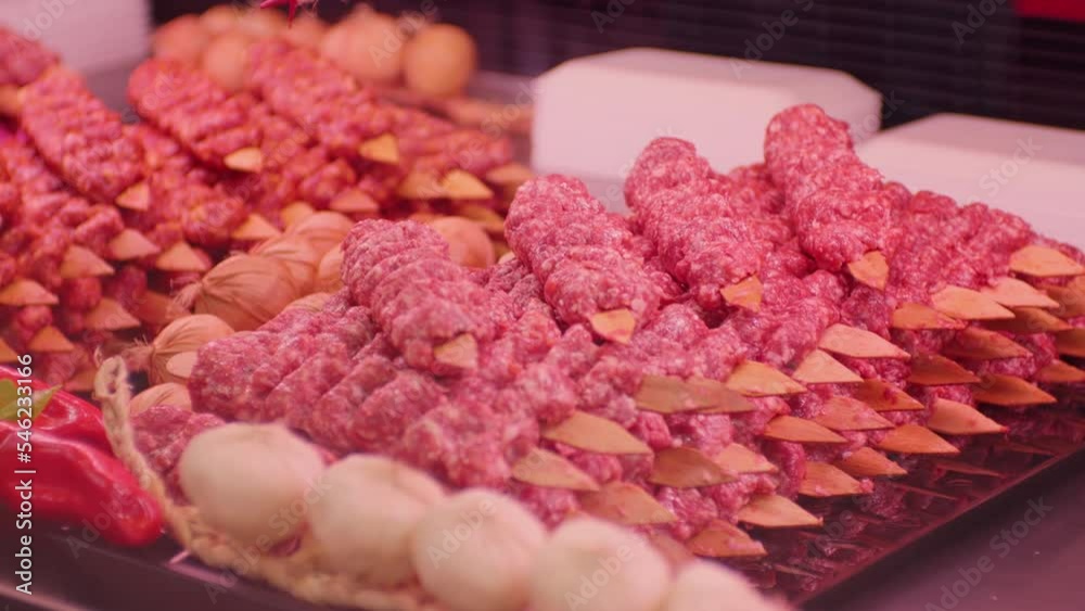 Turkish kebab on skewers with spices on showcase in butchers shop. Turkish cuisine on tray for display in a market. Turkish kebab on skewers with spices on showcase in butchers shop. Turkish cuisine on tray for display in a market.