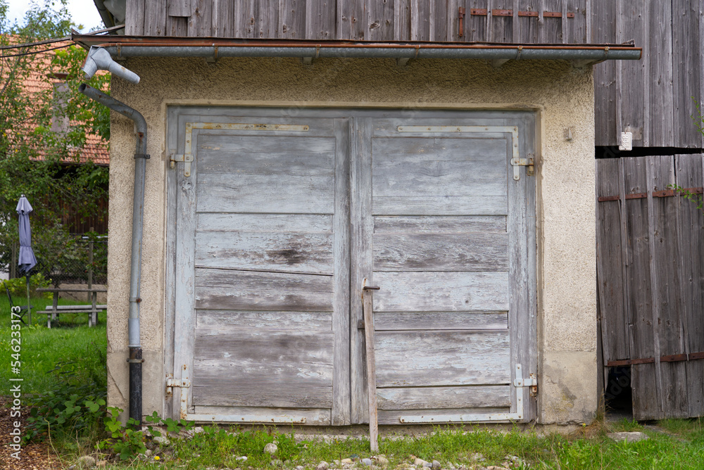 Weathered wooden gate of barn at rural village Kyburg, Canton Zürich, on a cloudy late summer day. Photo taken September 1st, 2022, Kyburg, Switzerland. Weathered wooden gate of barn at rural village Kyburg, Canton Zürich, on a cloudy late summer day. Photo taken September 1st, 2022, Kyburg, Switzerland.