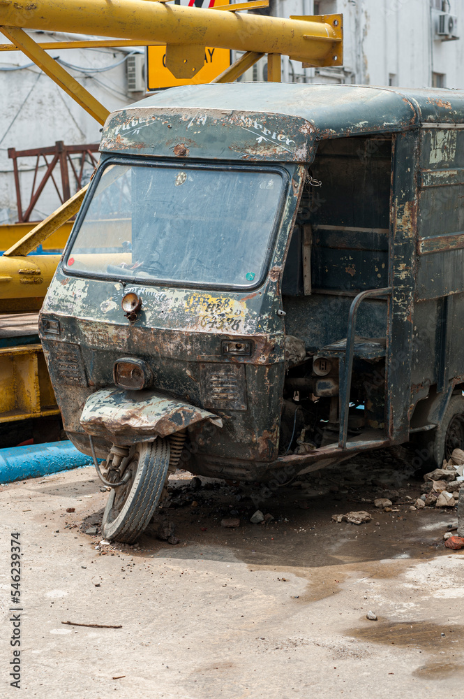 Abandoned and rusted tuk-tuk or auto rickshaw on roadside in India