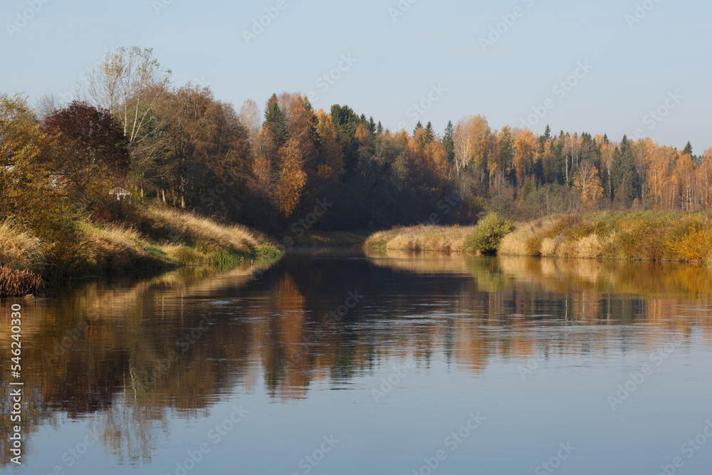 Autumn landscape with colorful trees reflected in the water.