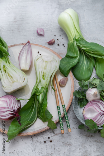 Obraz na płótnie Przygotowanie potrawy wegetariańskiej ze świeżą kapustą pak choi i zielonymi warzywami w salonie