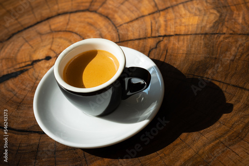 A cup of espresso on a wooden table.