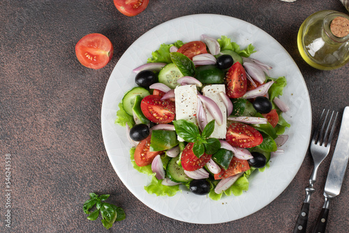 Classic Greek salad from tomatoes, cucumbers, sweet pepper, olives, basil and feta cheese