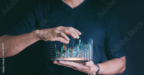 Hand of Businessman or trader is showing a growing virtual hologram stock on smartphone, invest in trading.planning and strategy, Stock market, Business growth, progress or success concept.