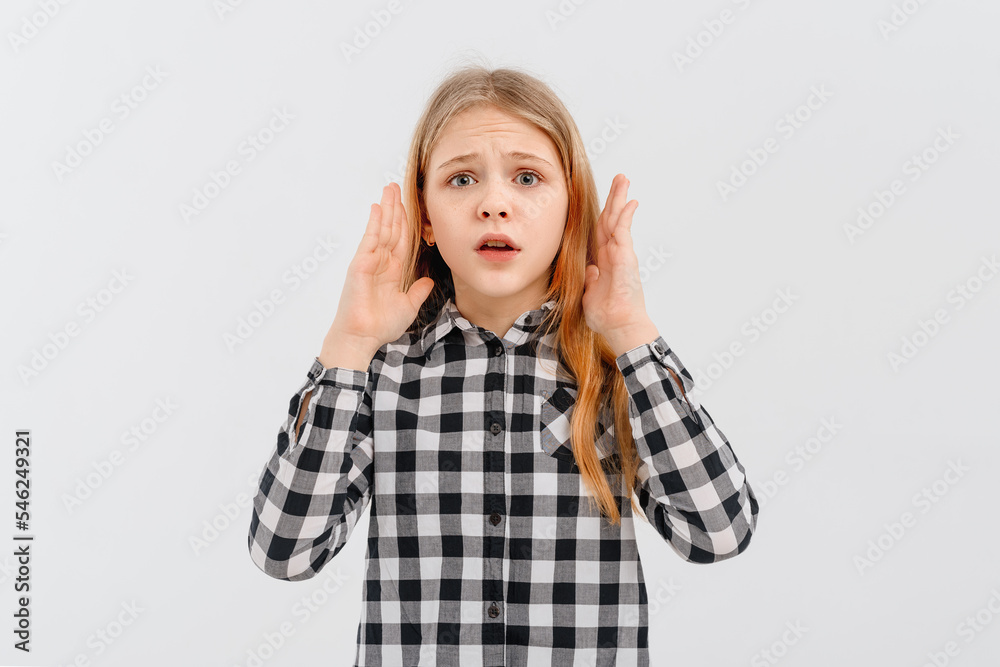 Portrait of girl with blonde hair looking shocked and concerned at camera, open mouth and furrow eyebrows startled, hear awful terrible news, stands in casual plaid shirt over white studio background Portrait of girl with blonde hair looking shocked and concerned at camera, open mouth and furrow eyebrows startled, hear awful terrible news, stands in casual plaid shirt over white studio background
