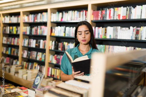 Latin smart woman enjoying a novel at the bookstore