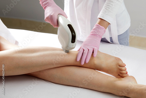 Laser hair removal on ladies legs in beauty salon
