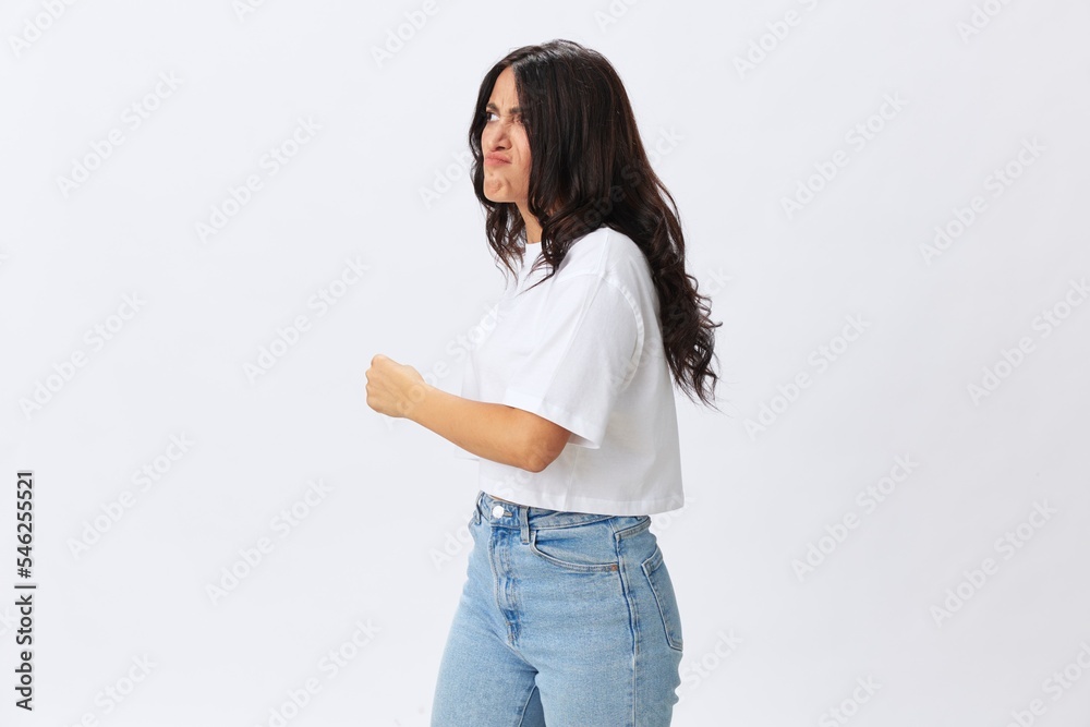 Woman in white t-shirt on white background brunette hands up gestures and signals poses in jeans emotion, lifestyle smiles, copy space Woman in white t-shirt on white background brunette hands up gestures and signals poses in jeans emotion, lifestyle smiles, copy space