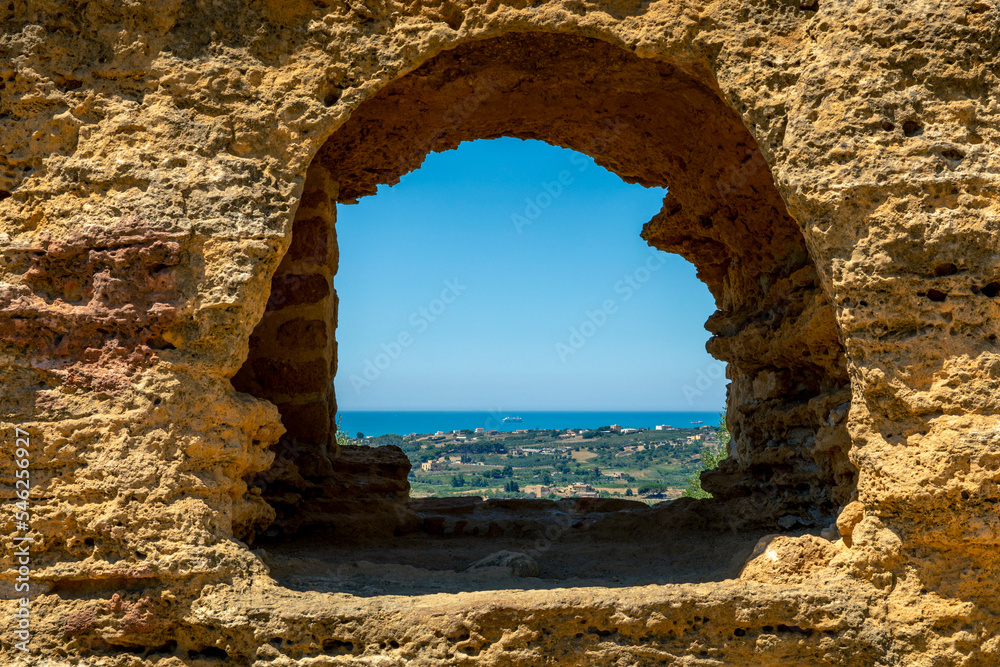 Agrigento, Sicily, Italy - July 12, 2020: Mediterranean sea seen through a hole in the wall of an ancient greek temple