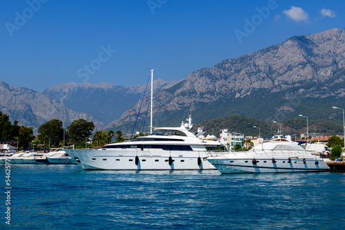 Super luxury Yacht moored in marina. Sunny weather. View from sea. Yachting, cruising, vacations, recreation concept.