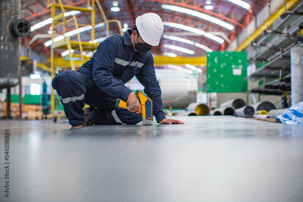 Obraz premium Male worker inspecting surface on plate stainless