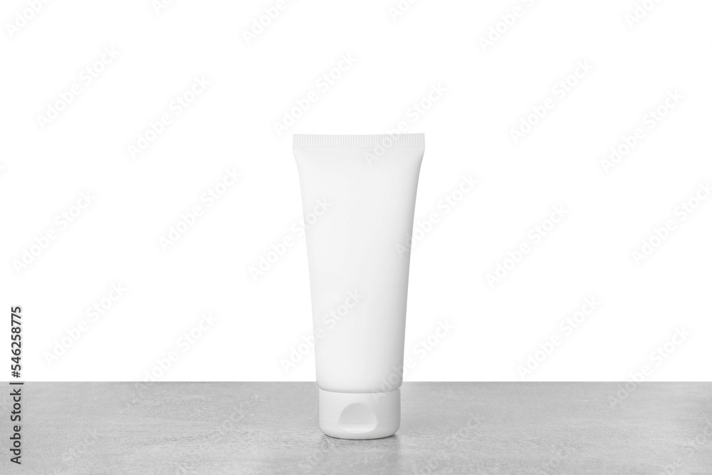 Tube of hand cream on gray table against white background Tube of hand cream on gray table against white background