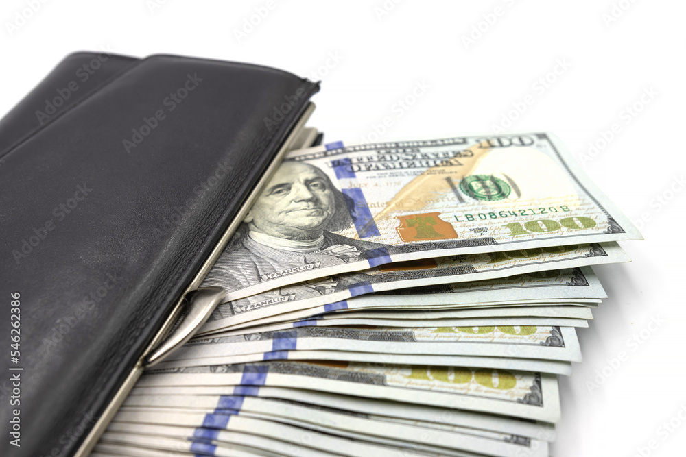 Cash from one hundred dollar bills in a wallet on a white background. A lot of US dollars in a black wallet. Cash from one hundred dollar bills in a wallet on a white background. A lot of US dollars in a black wallet.