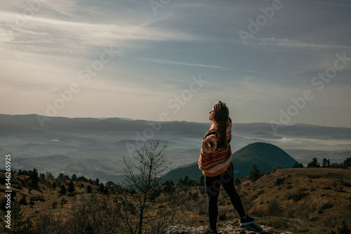 Woman standing on the rock among the mountains at sunny day in the forest in Turkey Bolu. Hiking concept.