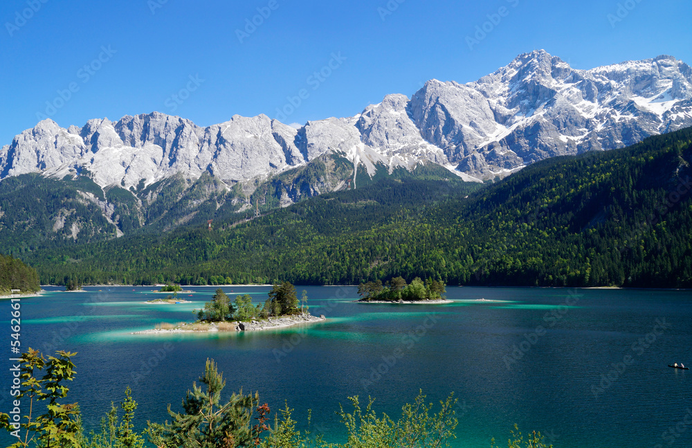 picturesque overgrown islands on turquois alpine lake Eibsee (yew lake) by the foot of mountain Zugspitze in the Bavarian Alps (the German Alps, Garmisch-Partenkirchen, Grainau, Bavaria, Germany)