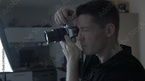 Close-up shot of a photographer looking down the viewfinder at his subject photo