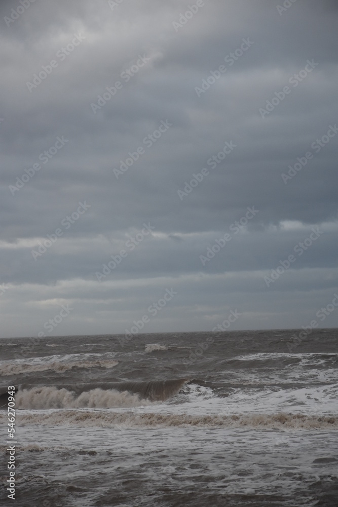 Waves crashing onto the beach and sea wall during high tide. Taken in Cleveleys Lancashire England. 