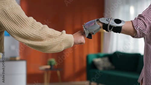 Cropped shot of young woman and man with bionic arm doing special hand gesture photo