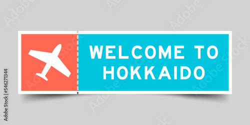 Orange and blue color ticket with plane icon and word welcome to hokkaido on gray background