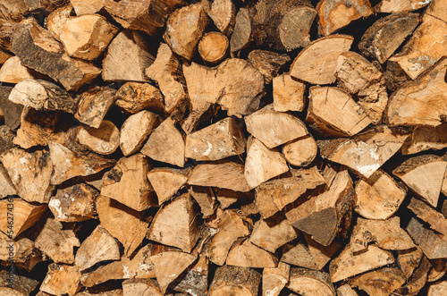 stack of neatly stacked firewood is dried under a canopy in the open air. Background for design. Cover.