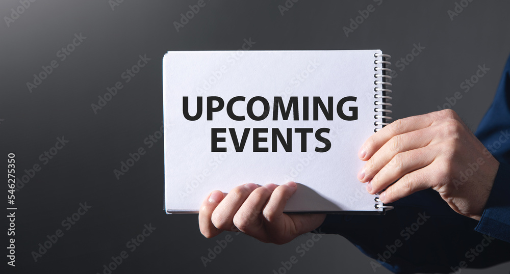 Male hands showing Upcoming Events message on notepad. Male hands showing Upcoming Events message on notepad.