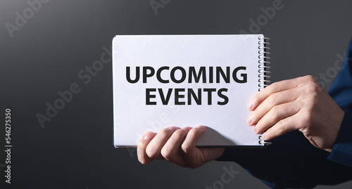 Male hands showing Upcoming Events message on notepad.