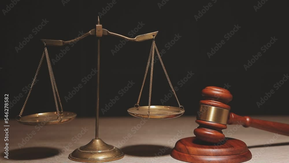 Justice and law concept.Male judge in a courtroom with the gavel, working with, computer and docking keyboard, eyeglasses, on table in morning light Justice and law concept.Male judge in a courtroom with the gavel, working with, computer and docking keyboard, eyeglasses, on table in morning light