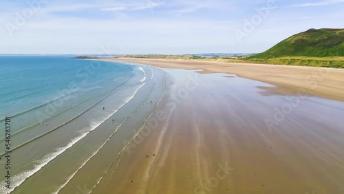 Aerial view flying along a huge and wide sandy beach at low tide